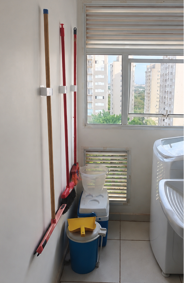 Vassouras e utensílios organizados na parede com suportes da Vetra